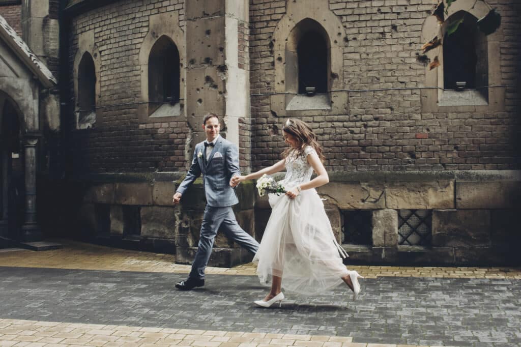 cinematic wedding - Beautiful, emotional wedding couple running and smiling in european city.